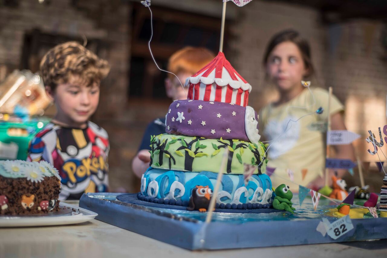 A large four tiered cake with brightly coloured icing.